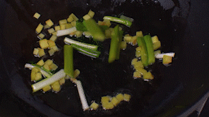 鍋中熱油，依次下姜粒、蔥段、蘆筍炒香。