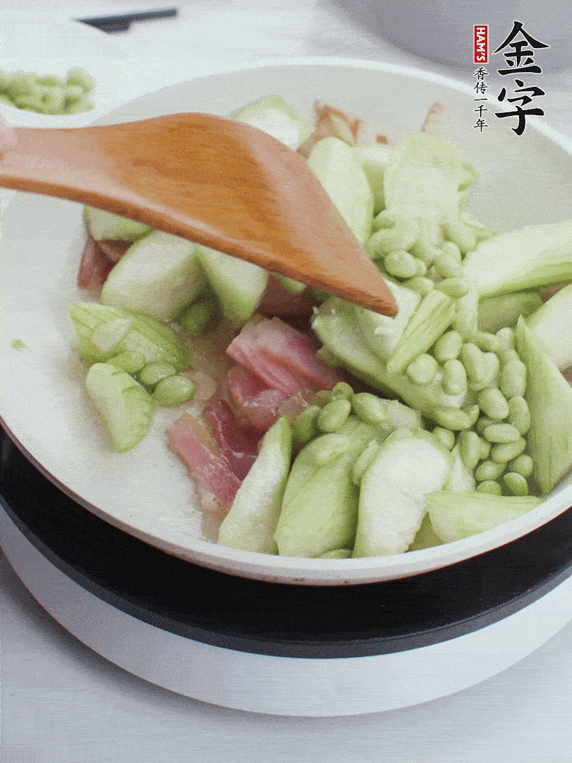 依次下絲瓜、青豆翻炒，炒至絲瓜打蔫縮小。