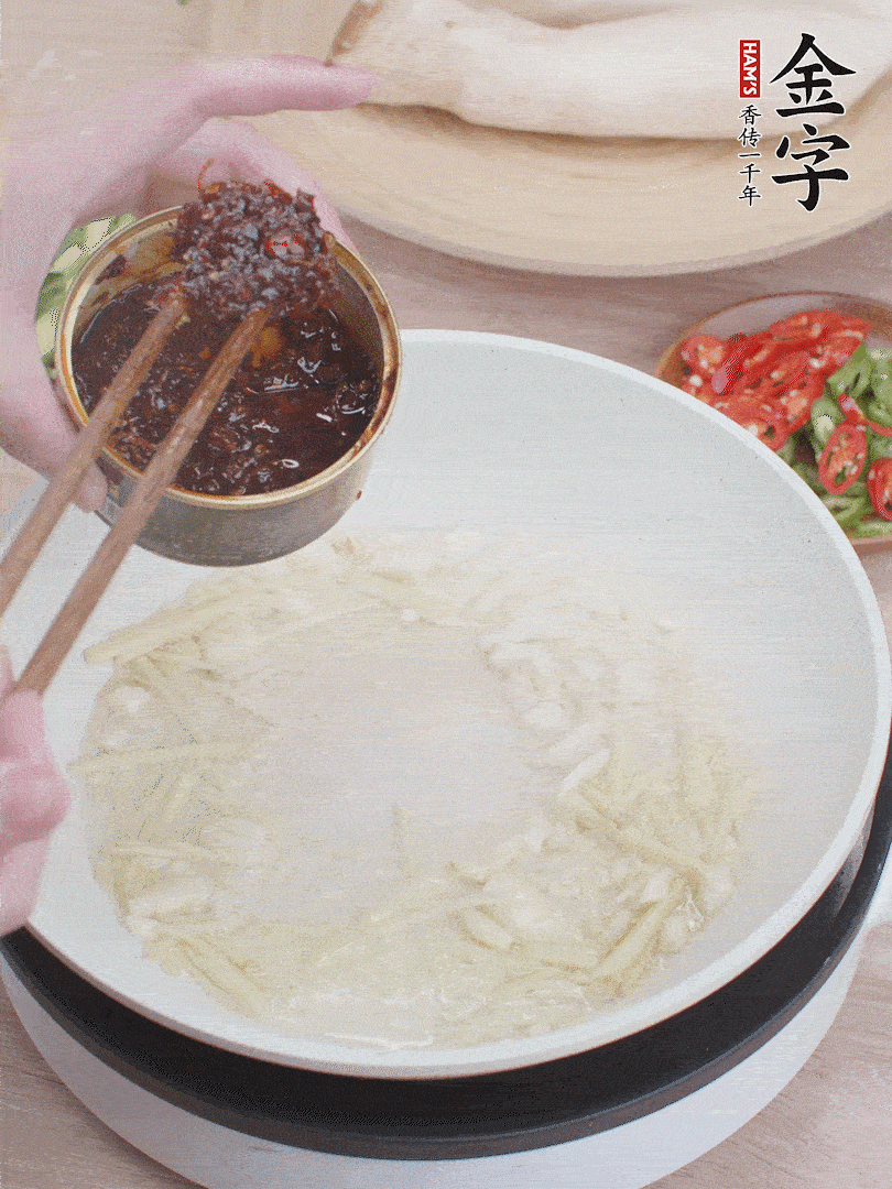 起鍋熱油，姜蒜、金字火腿干貝醬煸香。