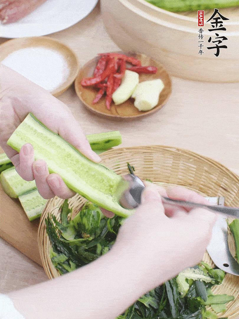 黃瓜削皮，對(duì)半切開，勺子挖去內(nèi)瓤，斜刀切片。青蒜斜刀切段。