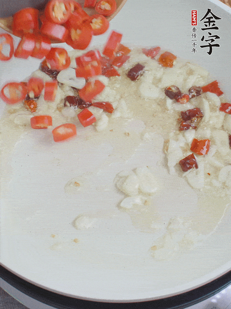 油6成熱，下蒜末、干紅辣椒煸炒，出香味后再放美人椒、香腸。