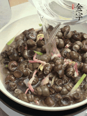 倒處理干凈的螺螄翻炒，加3勺料酒。加清水蓋過螺螄，中火蓋蓋煮5分鐘。