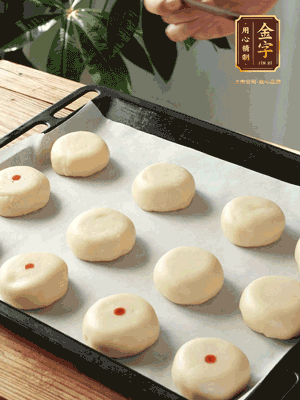 收口向下放在案板上，輕輕將月餅坯按扁，用筷子點紅點做裝飾