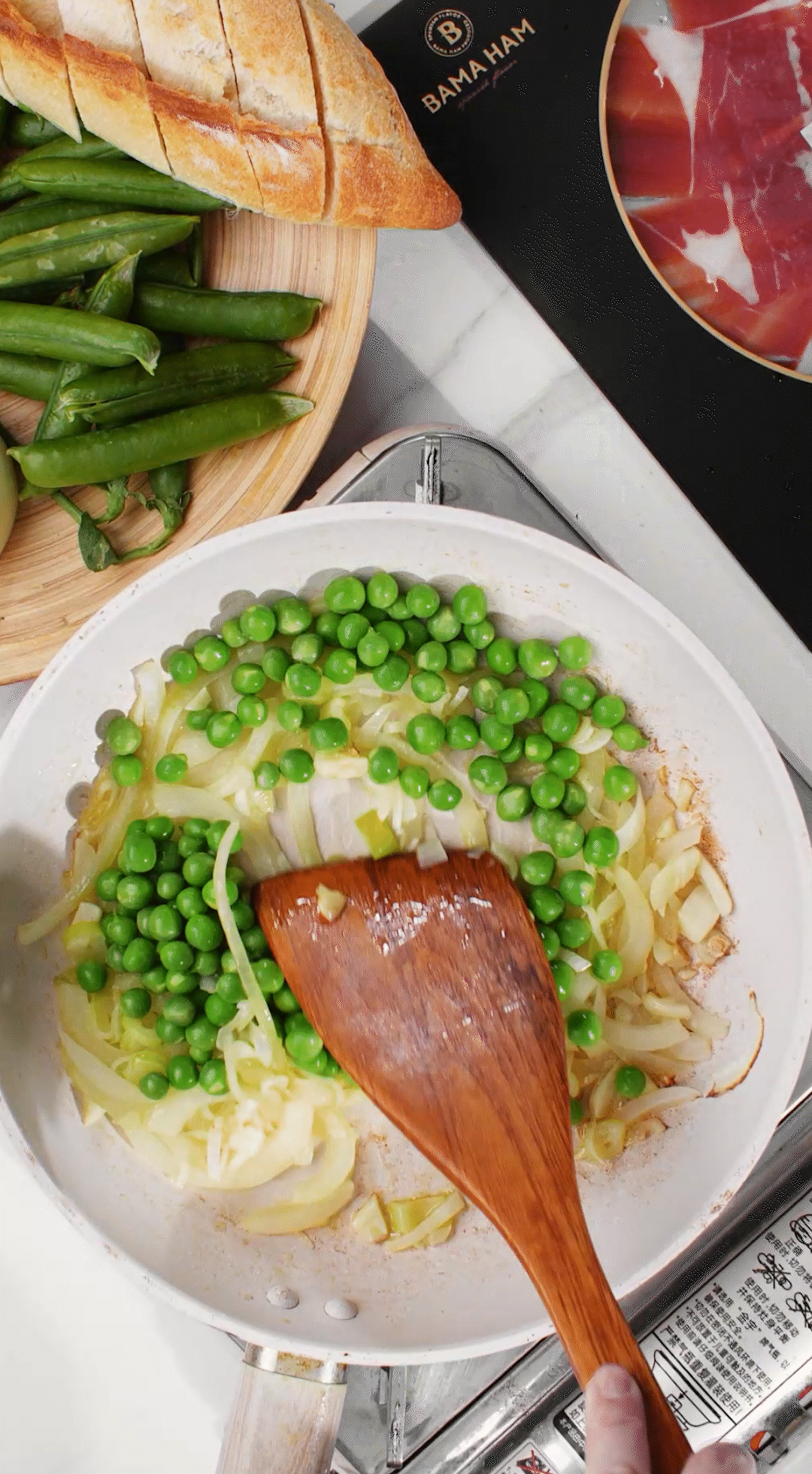 鍋中放入黃油融化，加入洋蔥絲、大蔥蔥白絲、蒜末翻炒變軟出香味。加入剛剛汆燙冰鎮(zhèn)后的豌豆，取出一點點待會擺盤裝飾用。加一點鹽 (和黑胡椒) 調(diào)味。