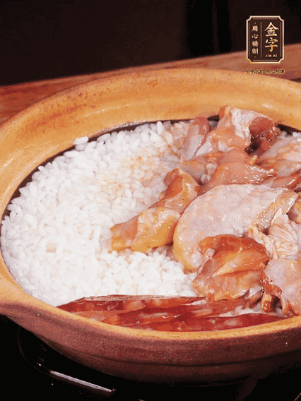 煮到椰子水微微收干轉(zhuǎn)小火，快速均勻鋪上雞肉、金字香腸